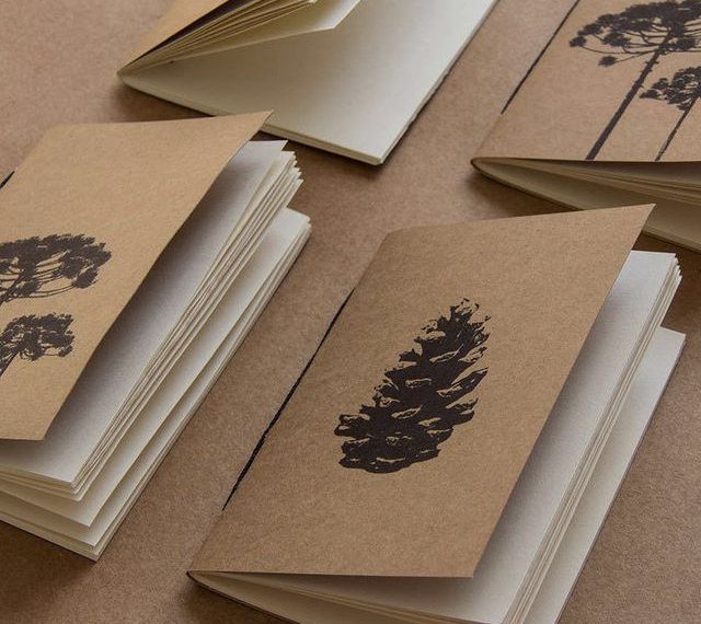 Caderno artesanal com capa em kraft e miolo em papel pólen, com estampa de pinha na capa